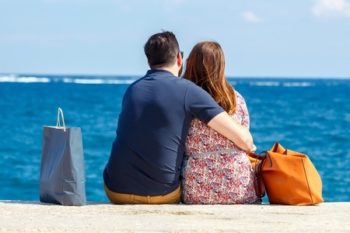 45865821 - man and woman on the beach in an embrace looking at the sea.